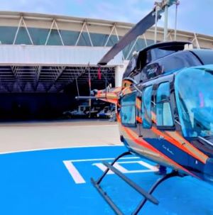 Piso epóxico de color azul brillante para helipuerto al aire libre con helicóptero de pasajeros de lujo estacionado